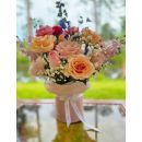 Elegant composition in a box, which includes roses, matthiola, delphinium, carnation, gypsophila, greenery